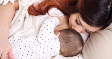 Six months old baby boy drinking breastmilk