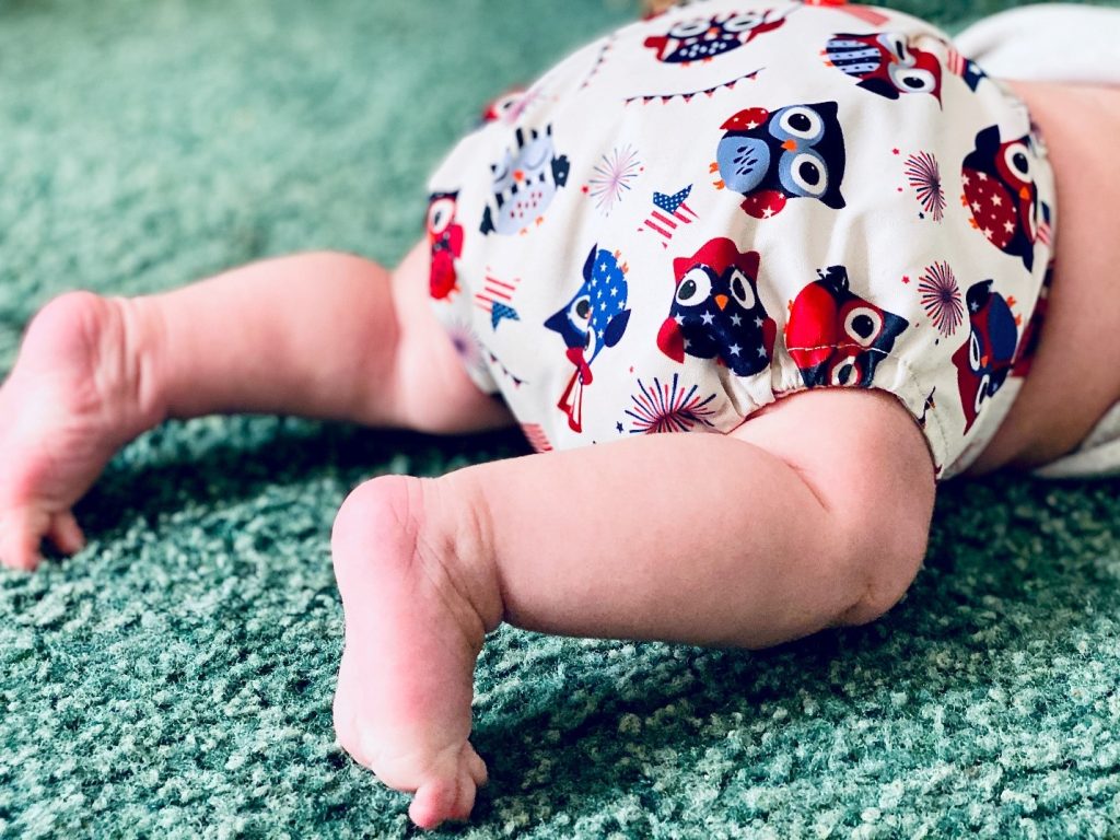 baby with an owl diaper facing downwards