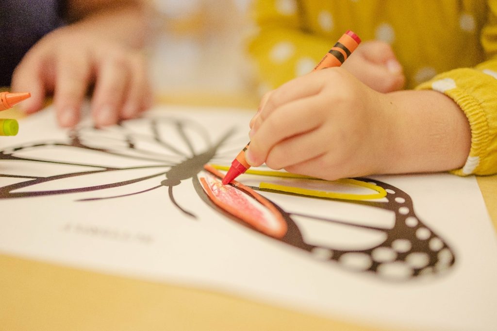 child coloring a butterfly