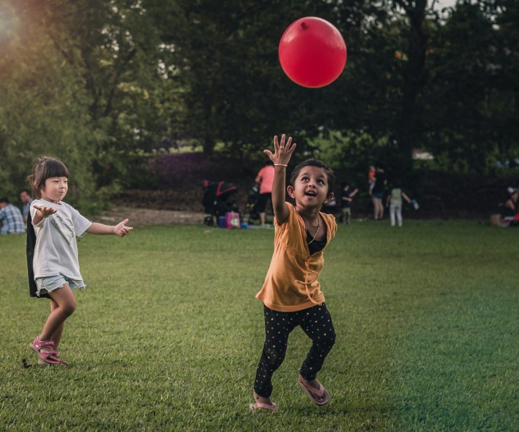 children playing balloon in the park