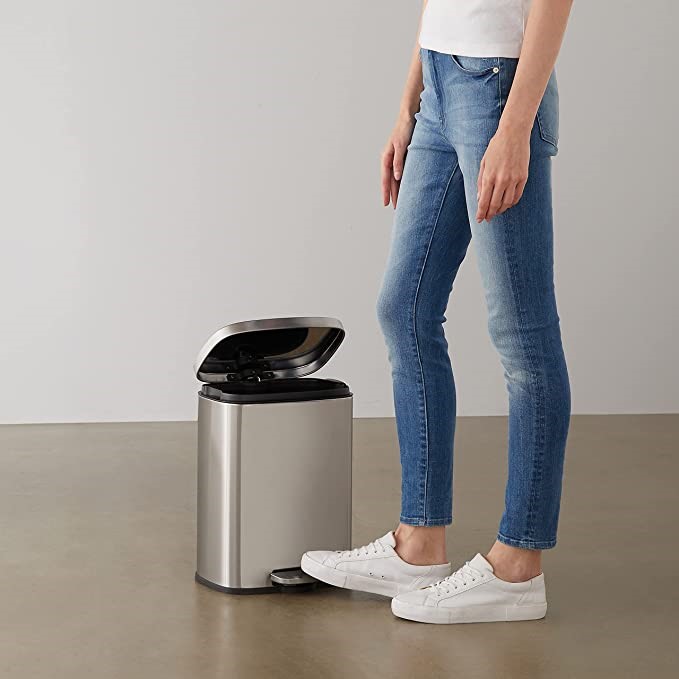 man stepping on a trash