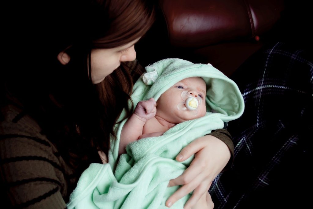 mom holding a baby with a pacifier