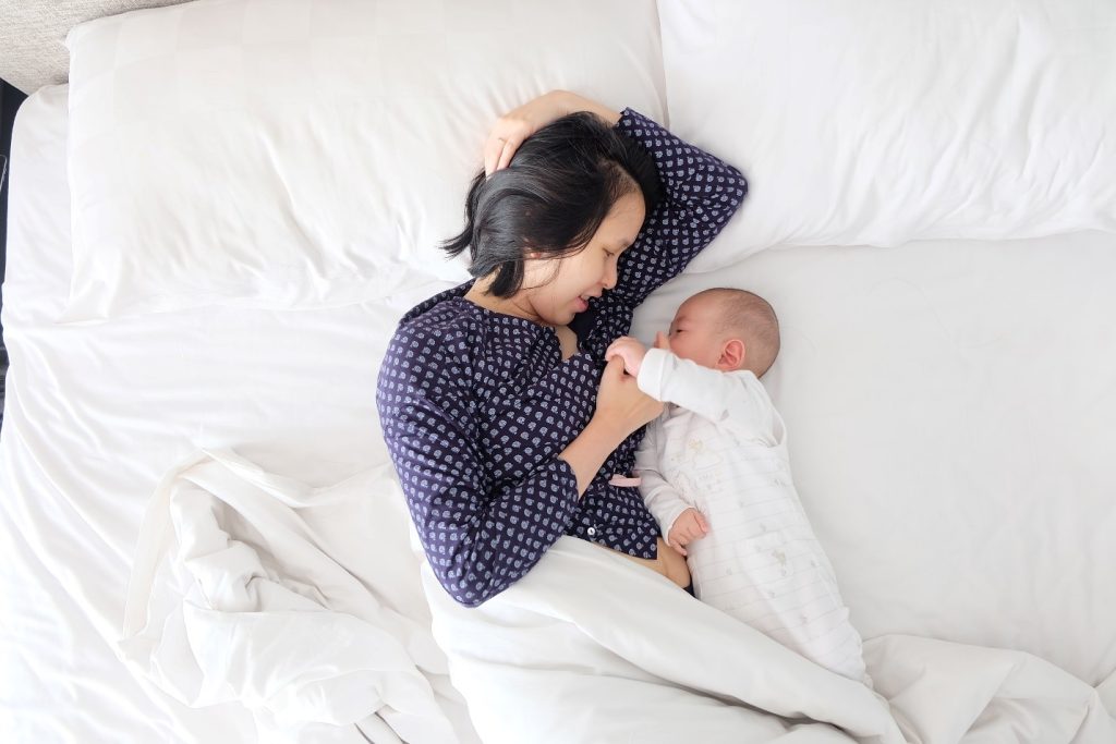 mom on the bed with her baby