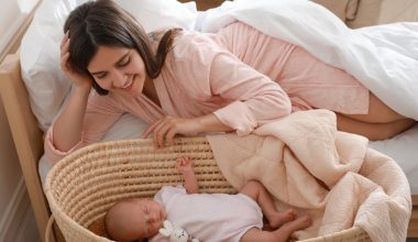 mom smiling over her baby on a bassinet