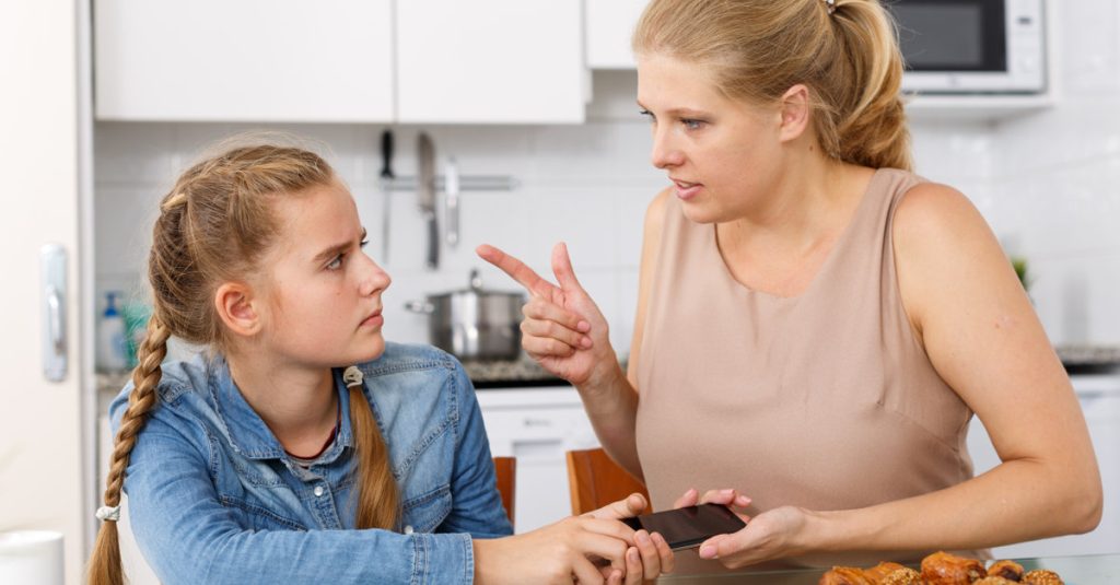 Mother taking away smartphone from her daughter