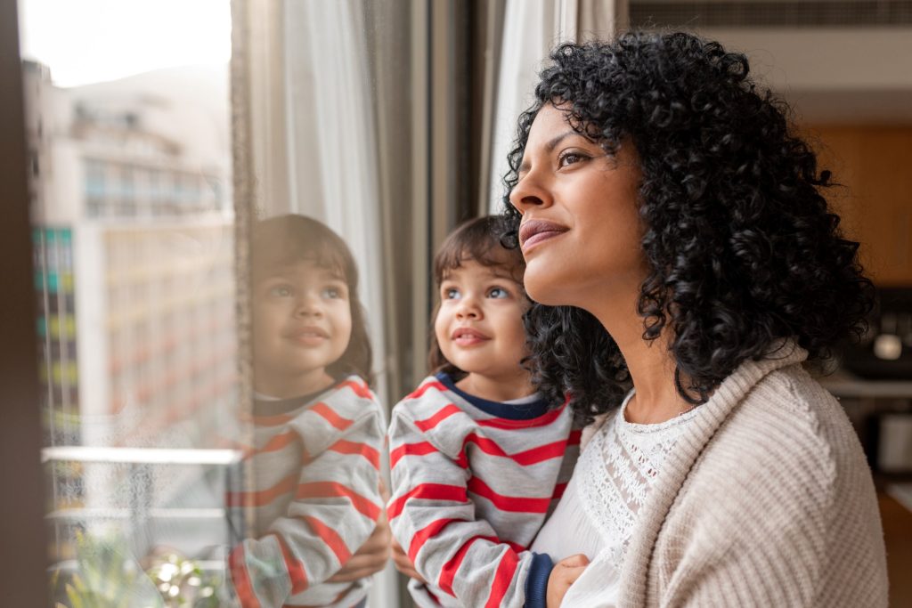 mother and daughter looking out the window