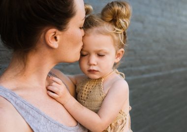 mother kissing her baby girl