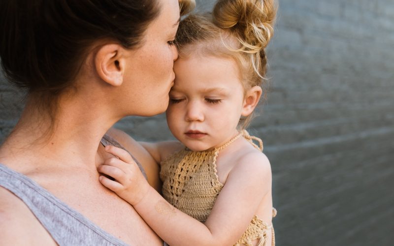 mother kissing her baby girl