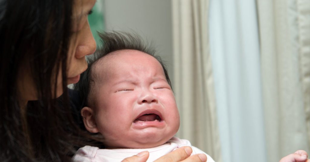 Mother is trying to comfort crying baby