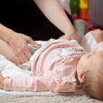 parent changing her baby's diaper