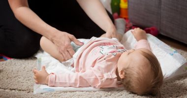parent changing her baby's diaper