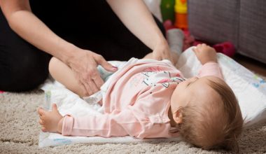 parent changing her baby's diaper