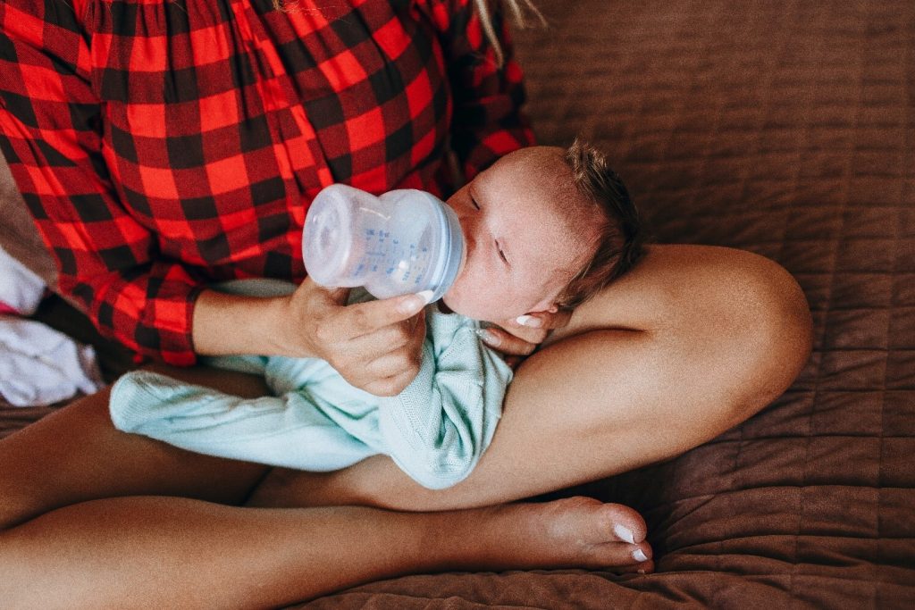woman feeding her baby bottled milk