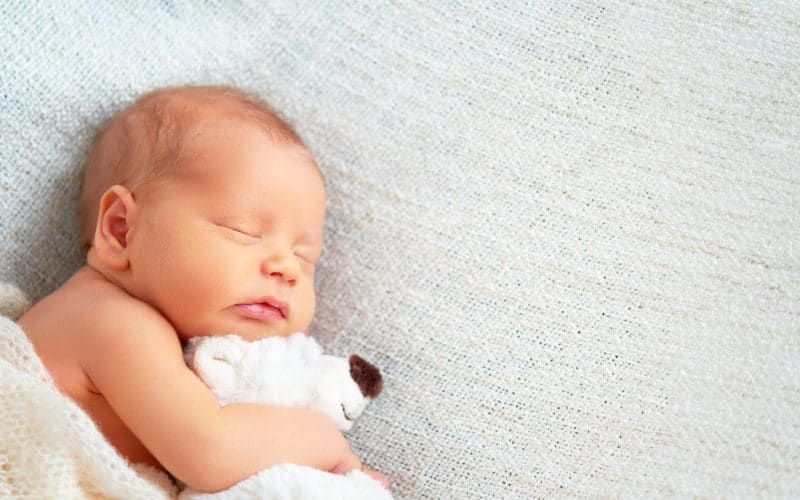 baby sleeping with teddy bear