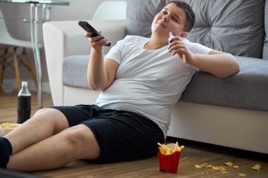 boy watching tv while eating fries