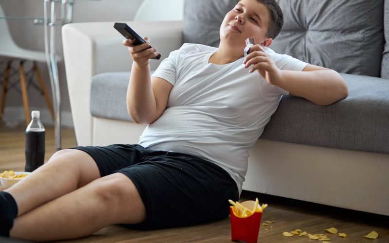 boy watching tv while eating fries