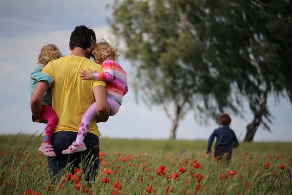 dad carrying two little girls