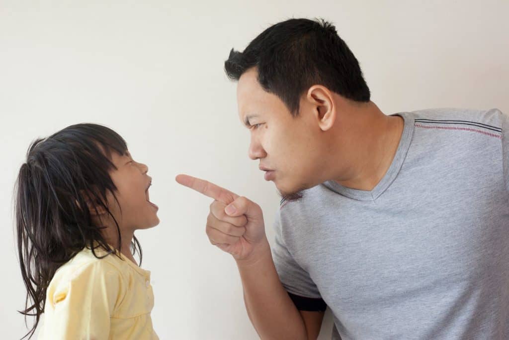 dad pointing fingers at crying child