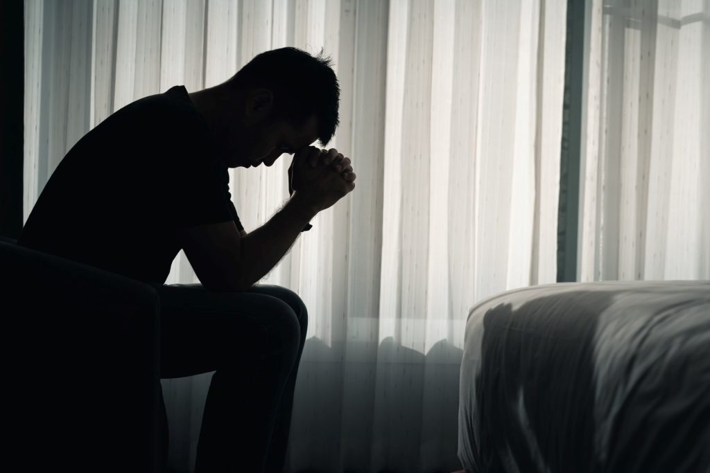 depressed man sitting on a bed