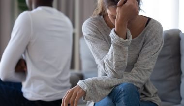 disappointed woman sitting on couch with partner