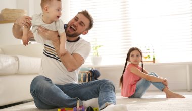 jealous girl while dad is playing with baby