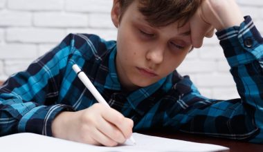 little boy falling asleep while studying
