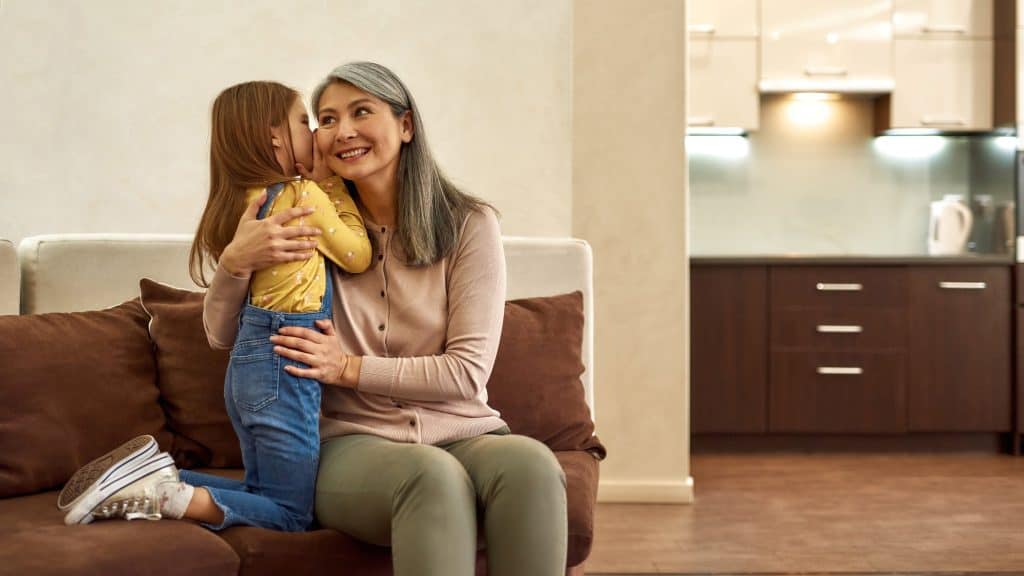 little girl whispering something on her grandma