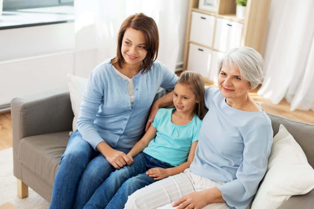 mother, grandma, and daughter watching TV
