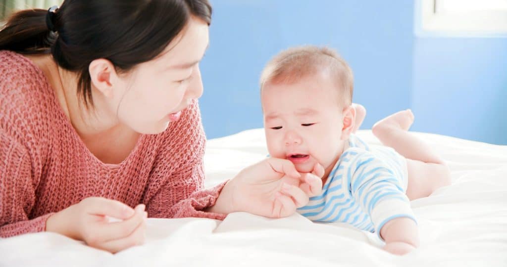 mother holding the chin of her baby