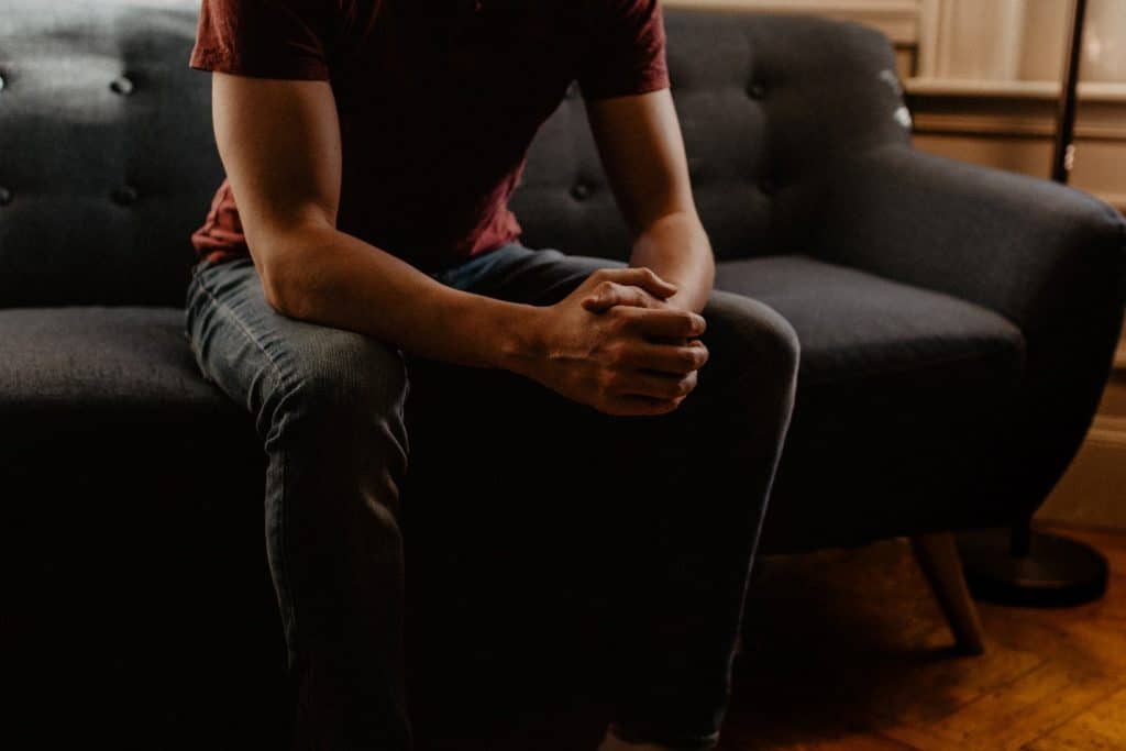 muscular man sitting on a couch