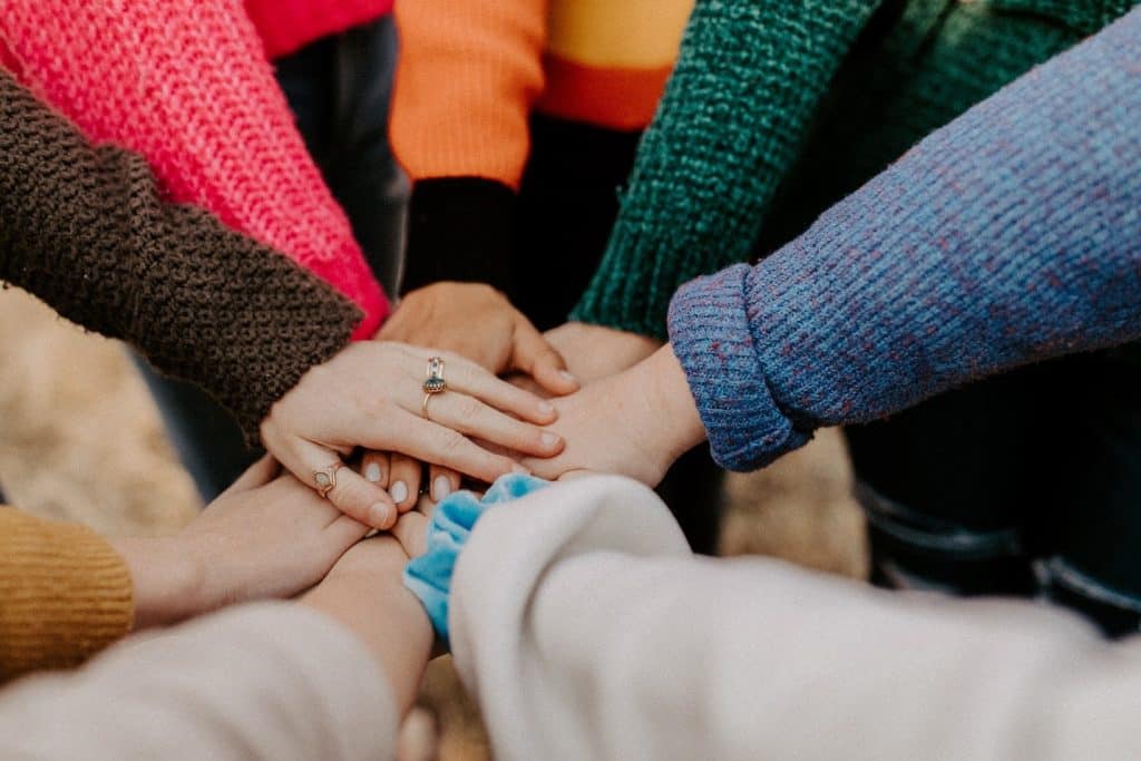 people placing their hands on top of each other