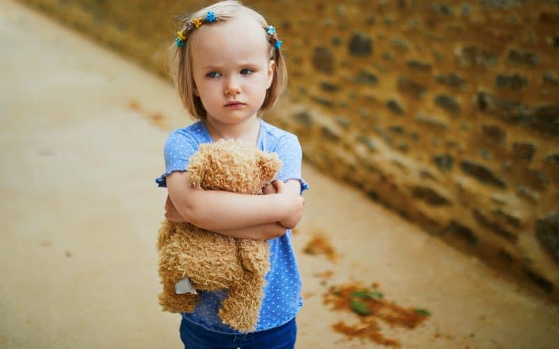 unhappy little girl on the street