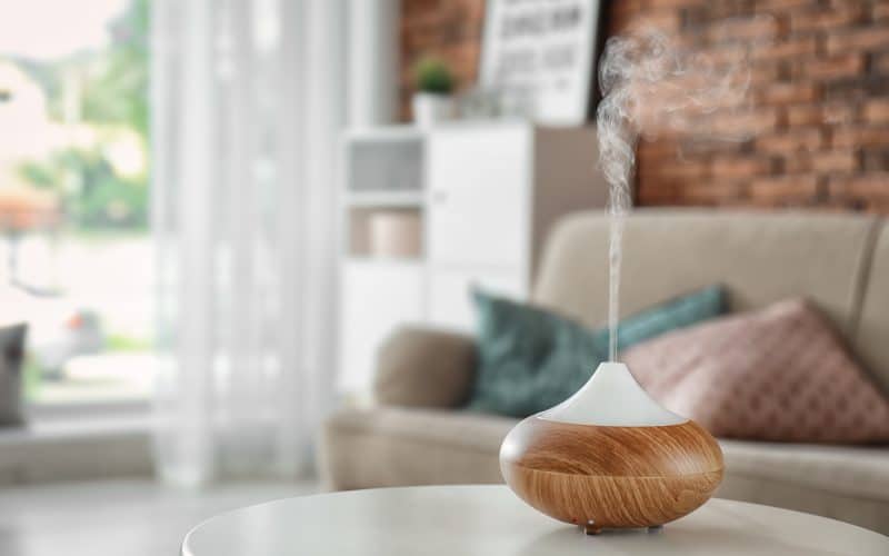 Aroma oil diffuser on table at home. Air freshener