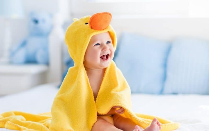 baby laughing wearing a duck towel