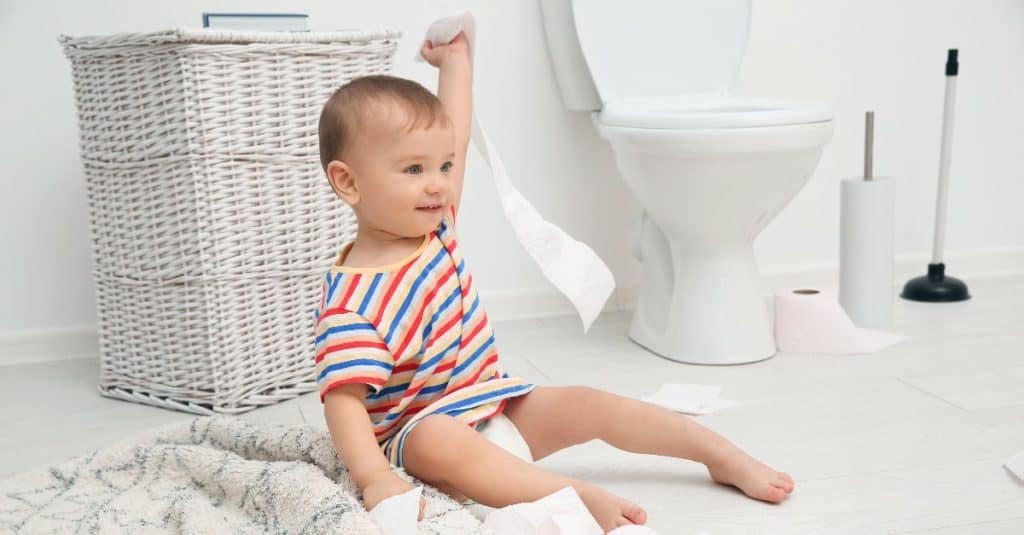 baby playing with toilet paper