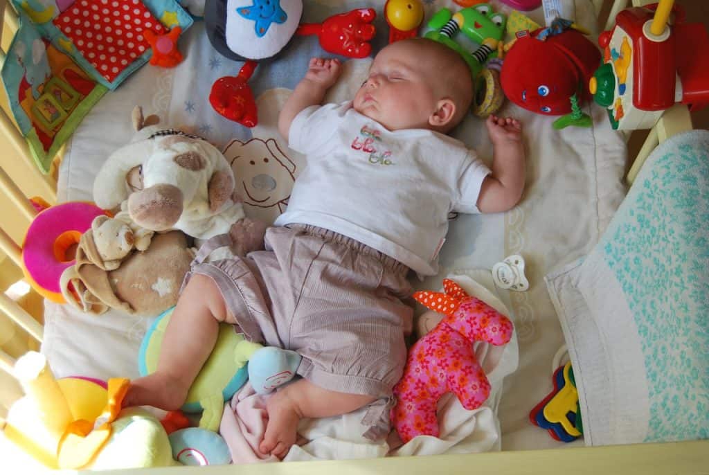 baby sleeping with a lot of toys
