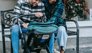 couple smiling at baby while on a stroller