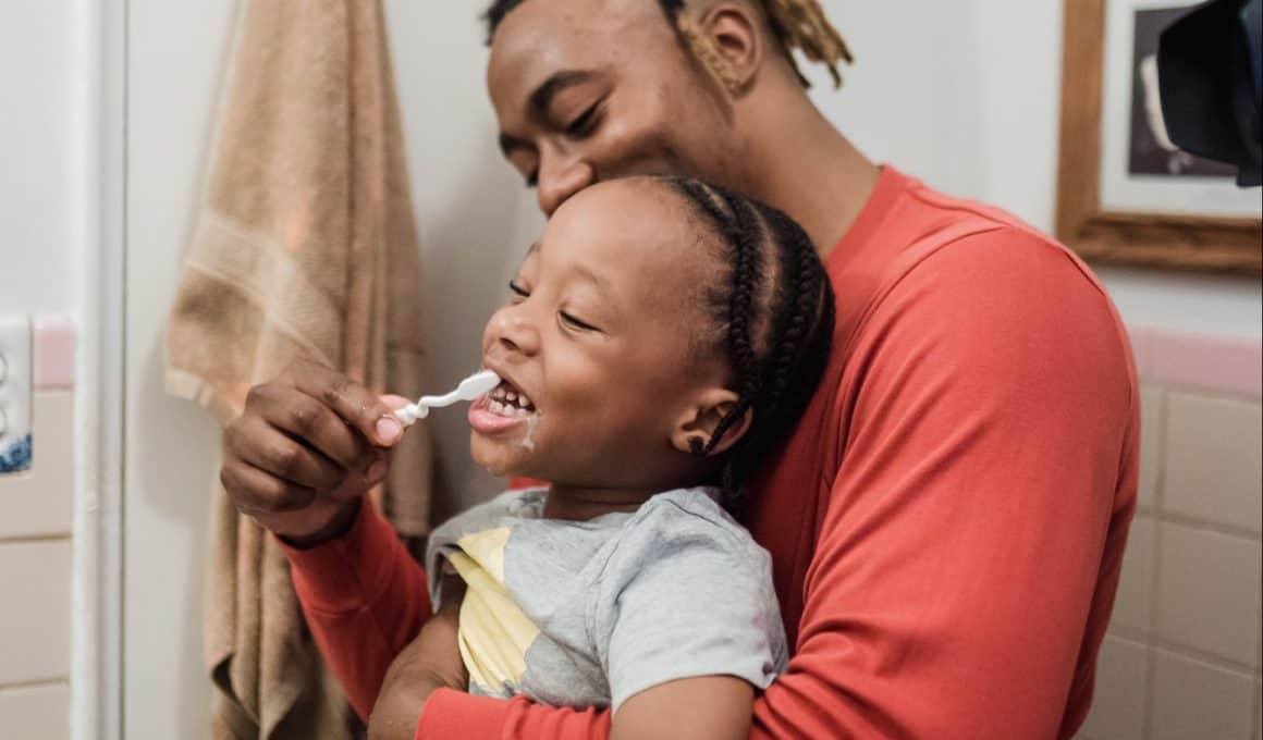 dad brushing son's teeth