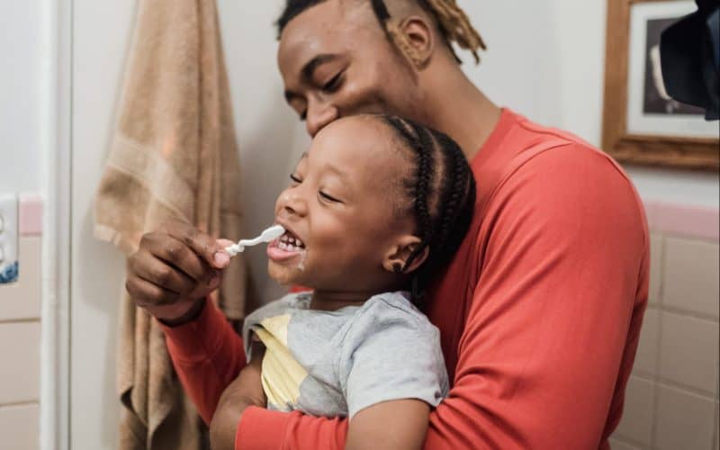 dad brushing son's teeth