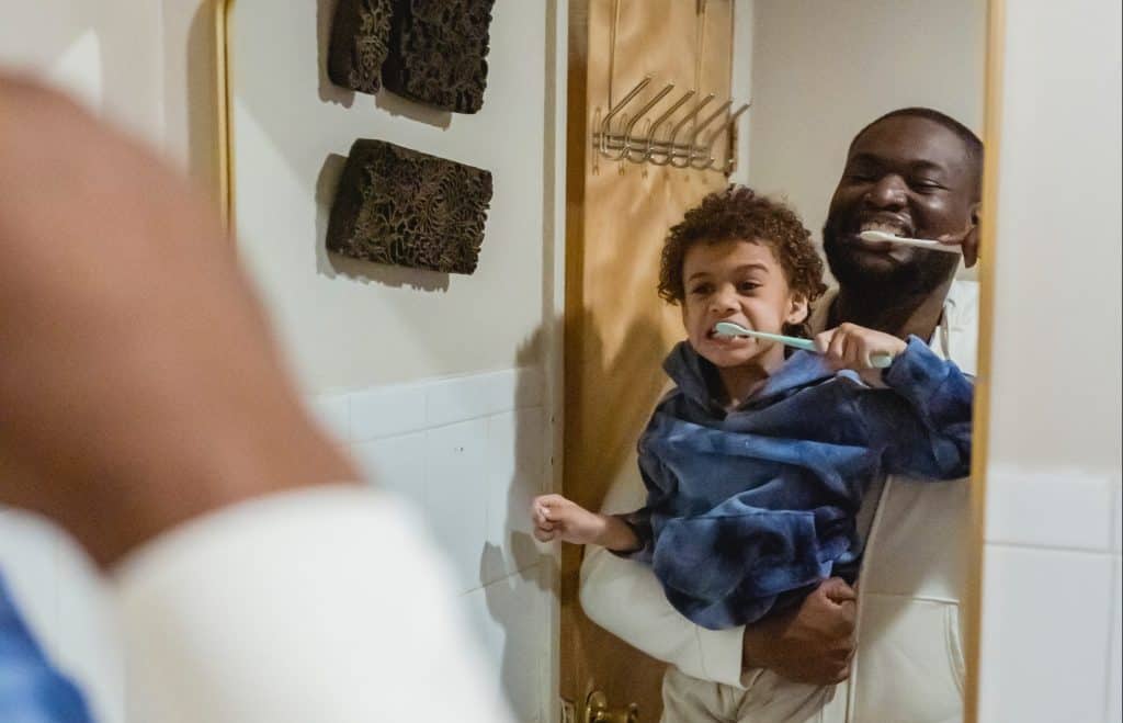 father and son brushing teeth