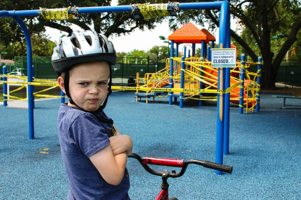 little boy making sour face at a park