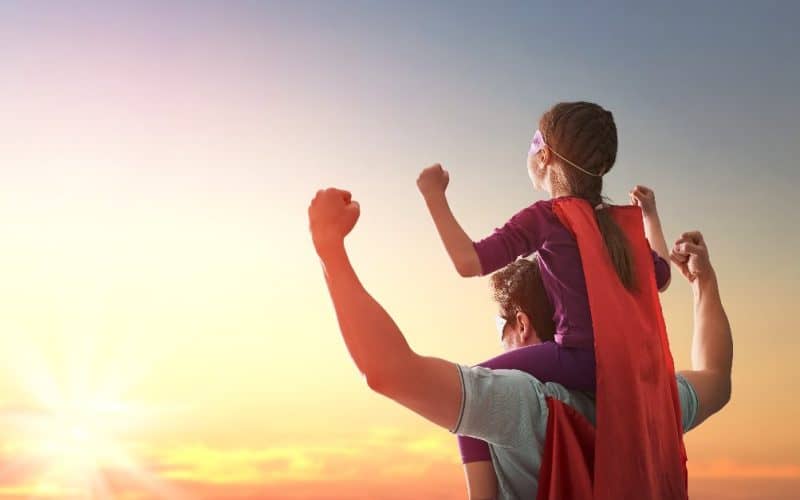 little girl and dad wearing a cape