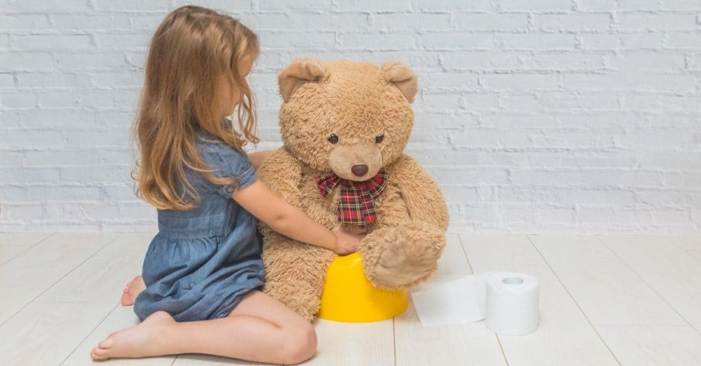 little girl potty training her teddy bear