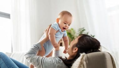 mother holding her baby up the air