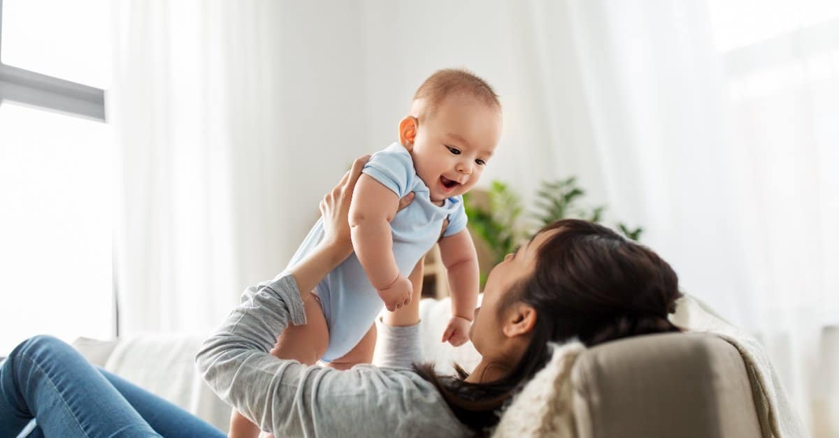 mother holding her baby up the air