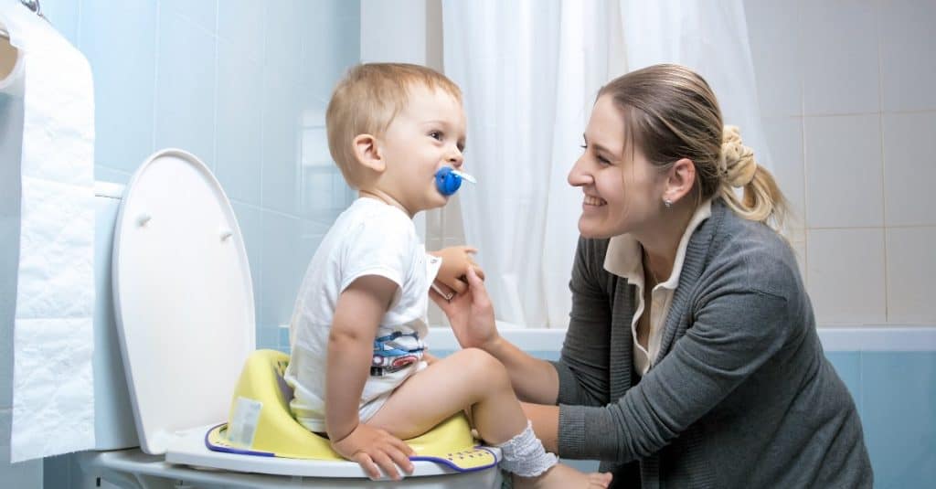 mother smiling at a toddler while in the toilet