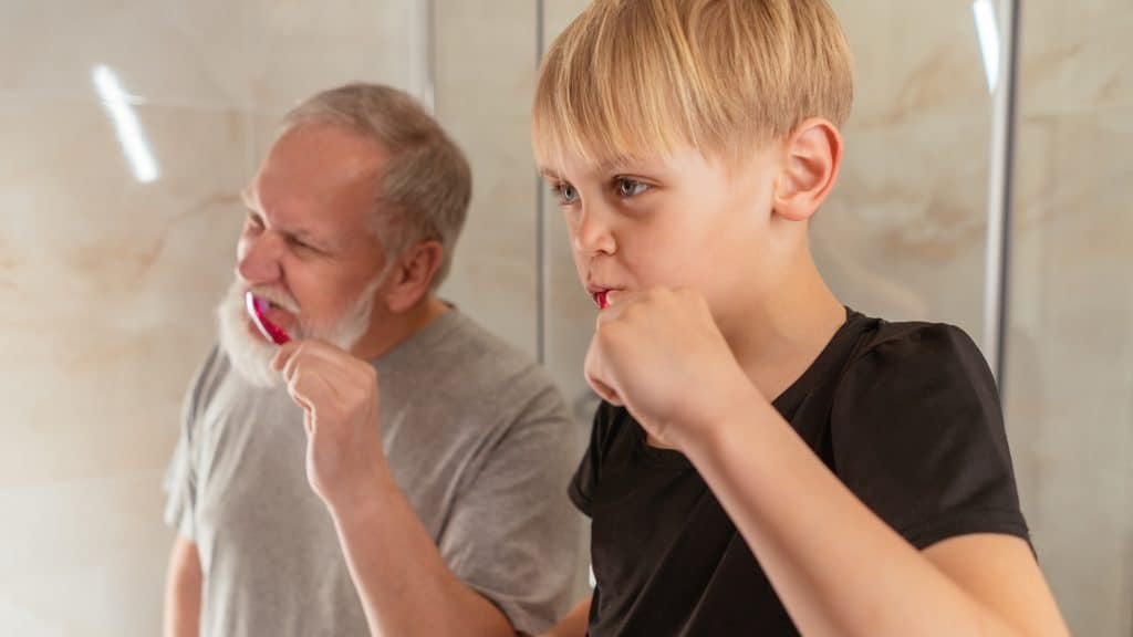 old man and son brushing teeth