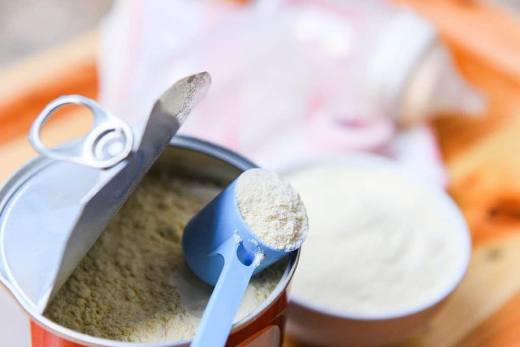 scooping formula milk from a can