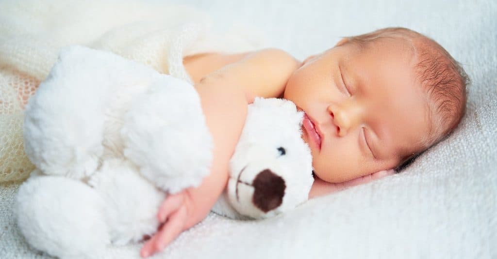 sleeping baby hugging a lovey