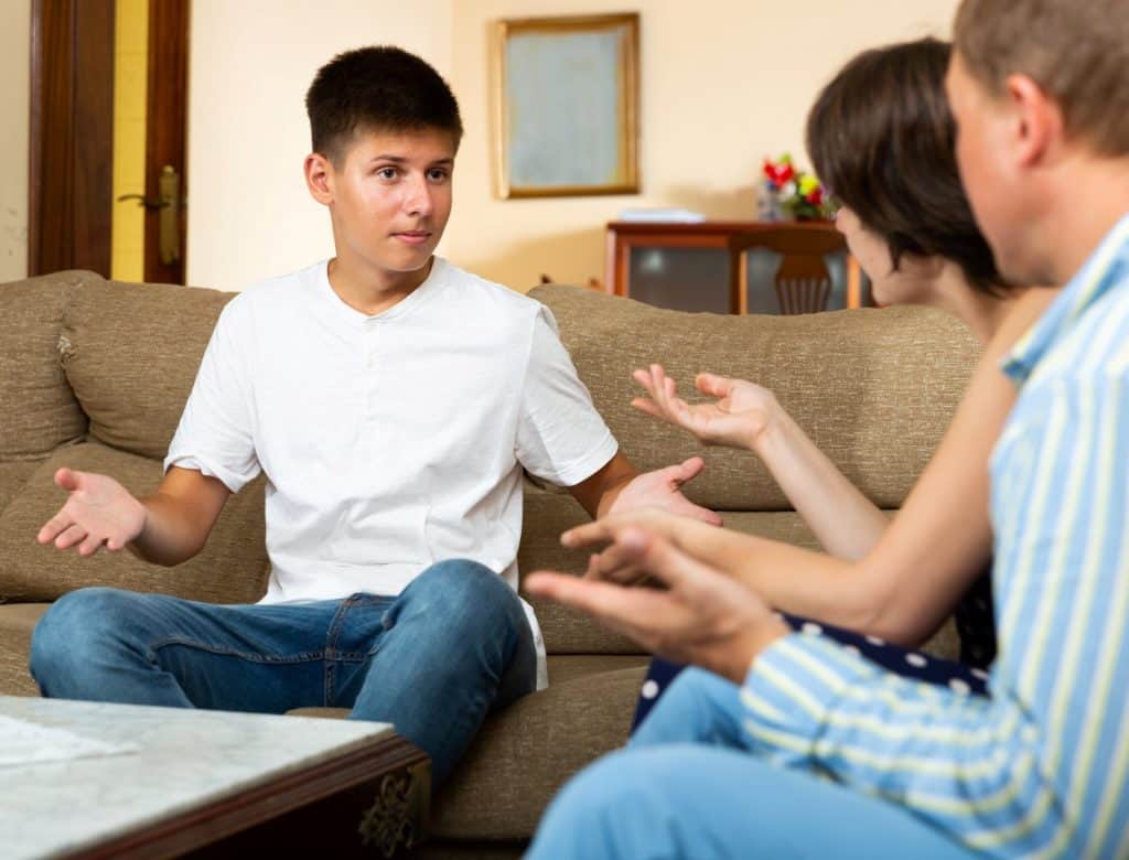 teenage boy explaining himself to his parents